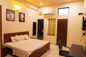 1 dormitorio con cama, escritorio y ventana en HOTEL GREEN HILLOCK en Alwar