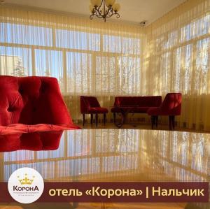 a living room with red chairs and a large window at Korona in Nalchik