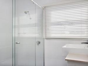 a bathroom with a glass shower and a sink at Bay Cottage in Callala Bay +14 photos