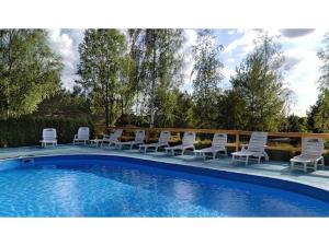 - un groupe de chaises assises à côté de la piscine dans l'établissement Hotel Niedźwiadek, à Wdzydze Kiszewskie