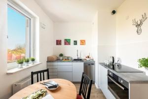 a kitchen with a wooden table and a dining room at Pokoje Sonaty in Warsaw