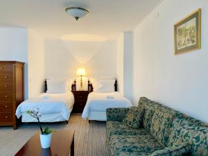 a living room with two beds and a couch at OPERA16 Guestrooms in Budapest