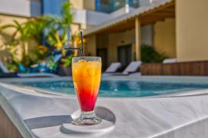 a drink sitting on a table next to a swimming pool at Island Boutique Hotel in Rhodes Town