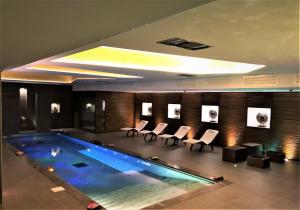 a pool in a hotel room with chairs and a table at Hotel Mirasole International in Gaeta