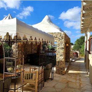 a pavilion with a white tent in a patio at לאורה - סוויטת אבן יוקרתית עם גינה, בר פרטי וג'קוזי מפנק in Umm el Shuf