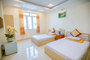 1 dormitorio con 2 camas y TV. en Quỳnh Trang, en Thường Son