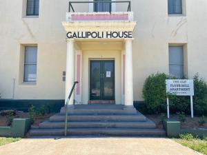 un bâtiment avec un panneau devant lui dans l'établissement Gallipoli House- The Loft Apartment, à Narrabri