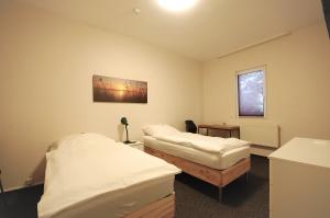 a hospital room with two beds and a window at Hotel Haus Isenburg in Neu Isenburg