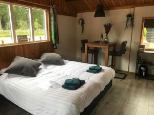 ein Schlafzimmer mit einem großen weißen Bett mit Handtüchern darauf in der Unterkunft Veluwse Bossuite in Otterlo