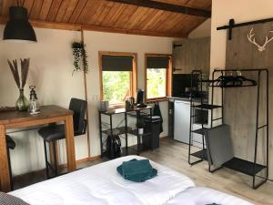 een slaapkamer met een bed en een keuken met een aanrecht bij Veluwse Bossuite in Otterlo