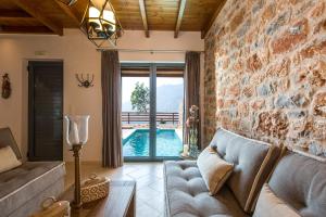 a living room with a couch and a stone wall at Galini Luxury Homes in Saktoúria +43 photos