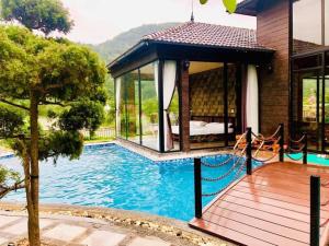 a villa with a swimming pool and a house at An Viên House Sóc Sơn Venuestay in Hanoi