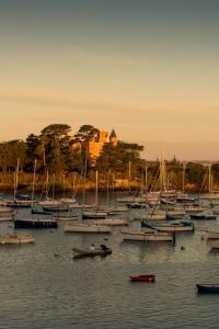 a bunch of boats in the water with a castle in the background at Le Nessay in Saint-Briac-sur-Mer