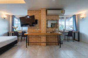 a room with a brick wall with a table and chairs at Little Bear's Home in Chiang Mai