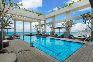 a swimming pool with a view of the ocean at Paris Deli Danang Beach Hotel in Danang