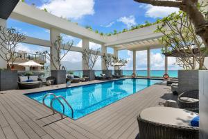 a swimming pool in a resort with a view of the ocean at Paris Deli Danang Beach Hotel in Danang