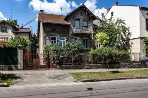 une maison avec une clôture en face d'une rue dans l'établissement Green Garden !svitlo postiyno!, à Lviv