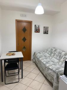 ein Schlafzimmer mit einem Bett, einem Tisch und einem Stuhl in der Unterkunft La casetta 75 in Neapel