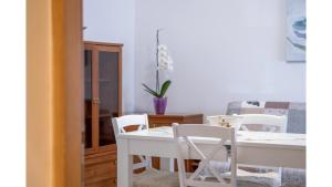 uma sala de jantar com uma mesa branca e cadeiras em Apartment Erin em Umag