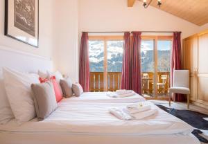 two beds in a room with a large window at Racers Retreat #5 in Wengen