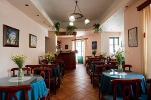 a restaurant with tables and chairs with flowers on them at Apollon Hotel in Naxos Chora