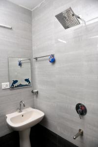 uma casa de banho com um lavatório branco e um espelho. em Maria Guest House em Palolem