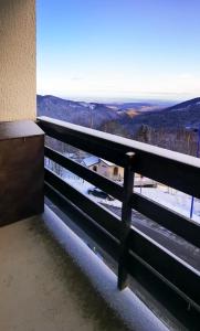 a balcony with a view of the snow covered mountains at Appartement au pied des Pistes de Ski - Pyrénées (Ariège) in Montferrier