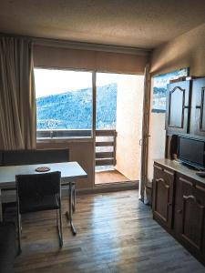 a living room with a table and a large window at Appartement au pied des Pistes de Ski - Pyrénées (Ariège) in Montferrier