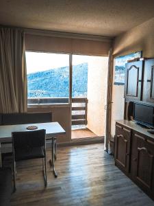 a living room with a table and a large window at Appartement au pied des Pistes de Ski - Pyrénées (Ariège) in Montferrier +4 photos