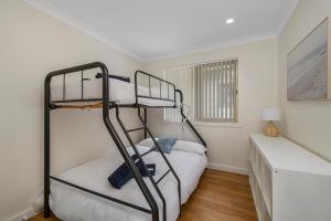 a bedroom with a bunk bed and a desk at Bellhaven 2, 17 Willow Street in Crescent Head