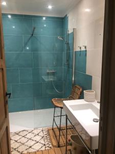 ein Badezimmer mit einer Dusche, einem Stuhl und einem Waschbecken in der Unterkunft karaktervolle woning met zwembad te Ronse in Ronse