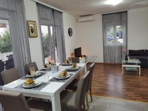 a dining room with a white table and chairs at Apartments Beciri in Sveti Vid-Miholjice
