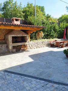 a patio with a stone fireplace and a table at Apartments Beciri in Sveti Vid-Miholjice