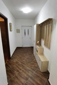 einen Flur mit einem Zimmer mit weißen Wänden und Holzböden in der Unterkunft Apartments Beciri in Sveti Vid-Miholjice