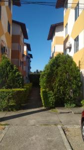 un callejón entre dos edificios de apartamentos con arbustos en Residencial Iracema Rua Atila Brandão, bairro Serraria, en Maceió