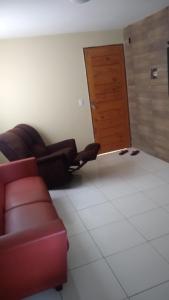 a living room with a red couch and a door at Residencial Iracema Rua Atila Brandão, bairro Serraria in Maceió