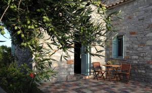 a table and chairs in front of a building at Palaeopoli Villas in Avlemonas