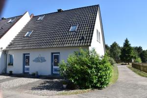 una casa blanca con techo negro en "Ostseefische" en Gutglück