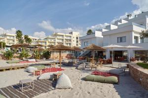 a sandy beach with chairs and umbrellas and tables at Can Salia in San Antonio Bay