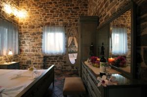 a bedroom with a large bed and a mirror at Palaeopoli Villas in Avlemonas