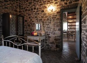 a bedroom with a bed in a stone wall at Palaeopoli Villas in Avlemonas
