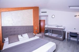 a bedroom with a large bed and a desk at Hotel Gabbiano in Rimini