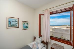 a bedroom with a window with a view of the ocean at Chateau Zevgoli in Naxos Chora