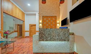 a lobby with a stone counter and a tv at Treebo Trend Sidhartha Inn Baliapanda in Puri