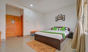 a bedroom with a large bed and a wooden door at Treebo Trend Sidhartha Inn Baliapanda in Puri