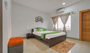 a bedroom with a large bed and a window at Treebo Trend Sidhartha Inn Baliapanda in Puri