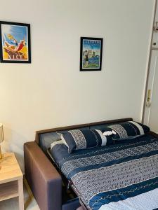 - un lit dans une chambre avec 2 photos sur le mur dans l'établissement Charmant Studio en bord de Mer, à Nice