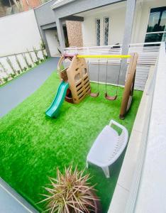 um pequeno quintal com um parque infantil com um baloiço em CWB 997 com piscina aquecida jacuzzi e Playground em Curitiba