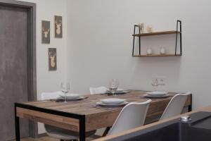 stół jadalny z białymi krzesłami wokół niego w obiekcie Waldfrieden Ferienhaus mit SAUNA w mieście Ruhla