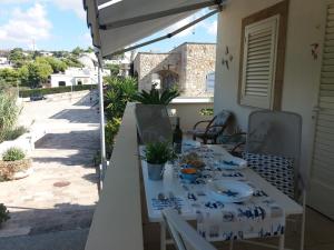 una mesa blanca con platos de comida en el balcón en Appartamenti Baia Azzurra, en Leuca